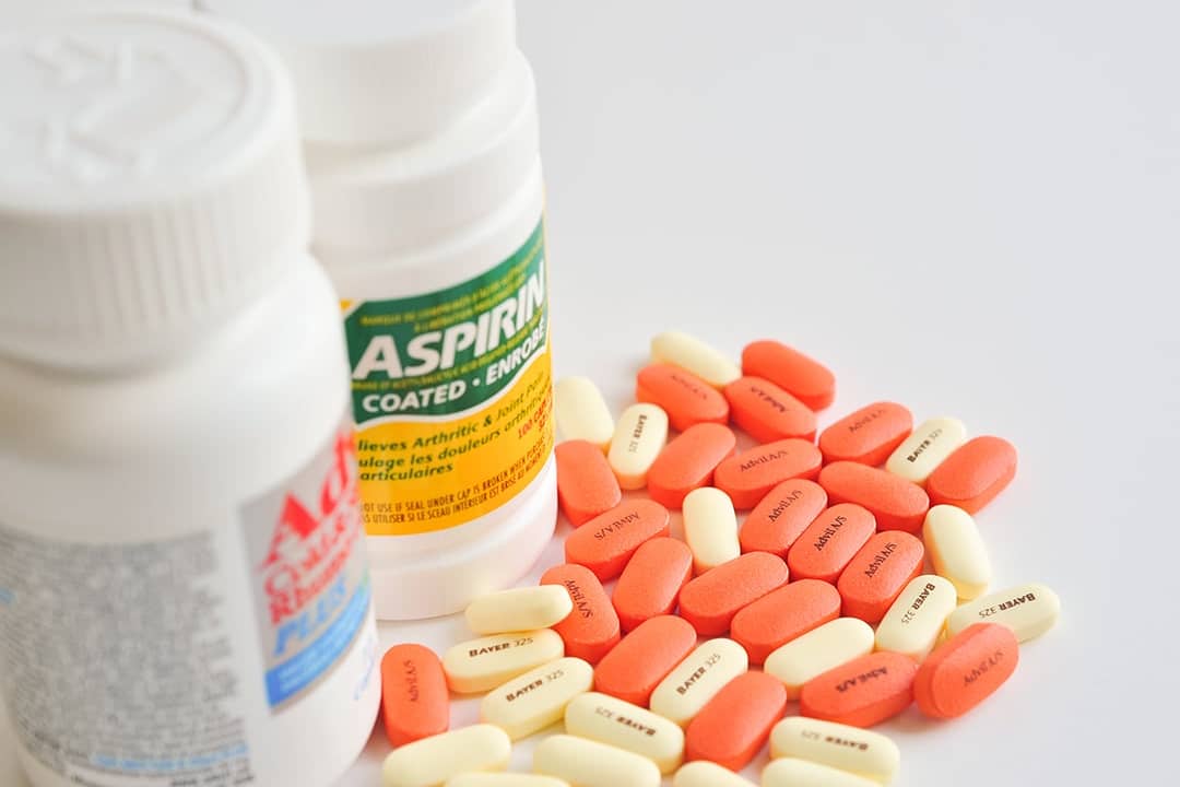 A bottle each of aspirin and ibuprofen pills